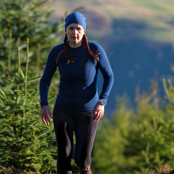 Woman running wearing Loomi Betatec Long Sleeve Merino Base Layer.