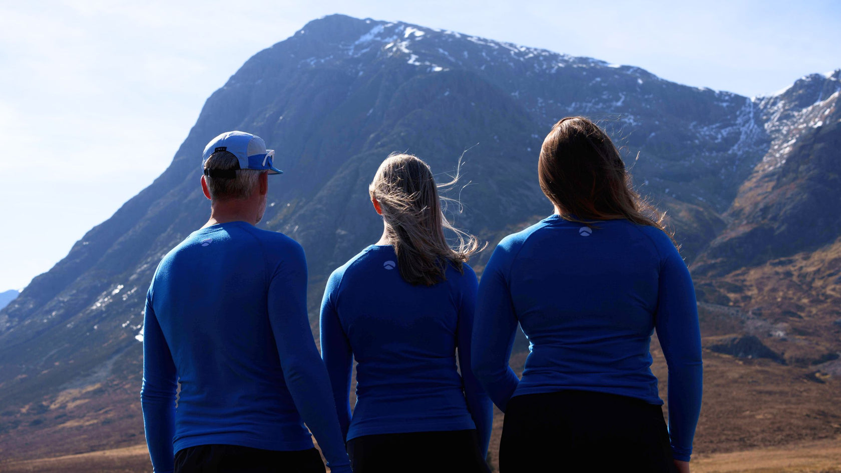 Three runners wearing Loomi Merino Base Layers enjoying a mountain view.