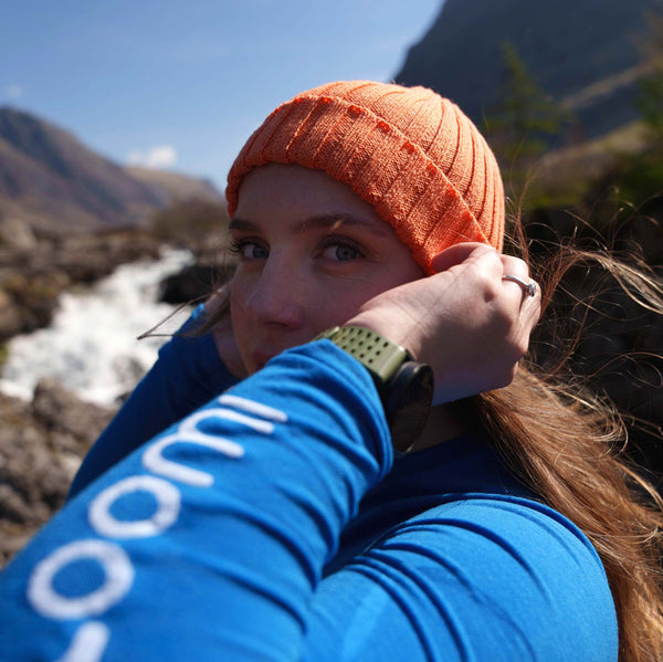 Woman wearing Loomi Merino Rib Beanie with mountains in background. 
